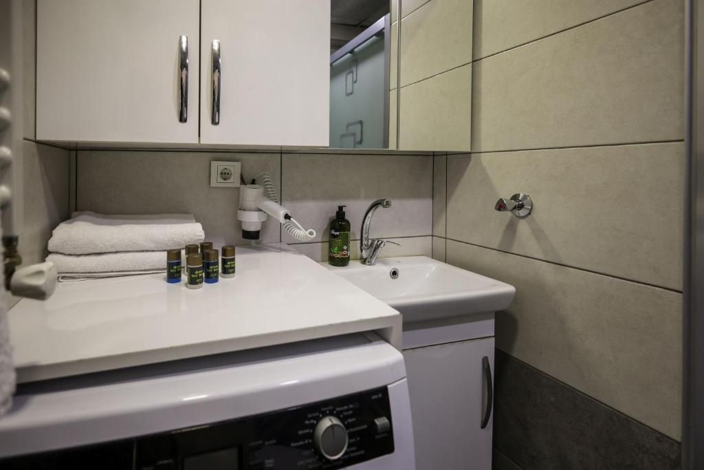 A hotel bathroom with a washing machine, a sink, and toiletries.