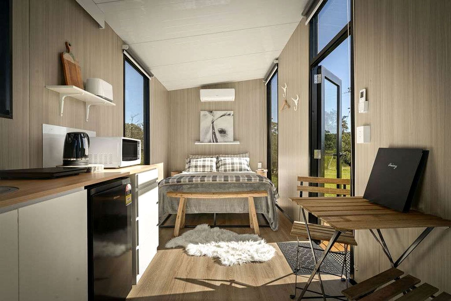 A compact bedroom with a bed, a desk, and a chair.