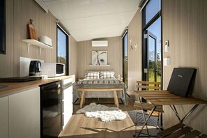 A compact bedroom with a bed, a desk, and a chair.