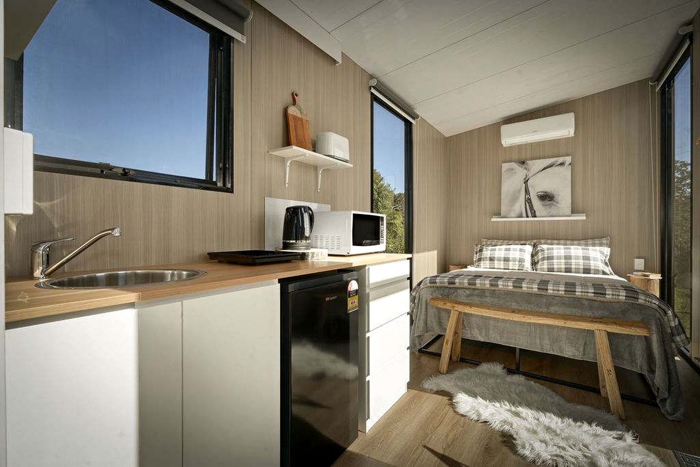 Een moderne slaapkamer met een houten bed, een nachtkastje en een raam.