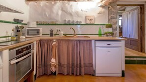 Cozinha compacta com máquina de lavar louça embutida, micro-ondas e pia.