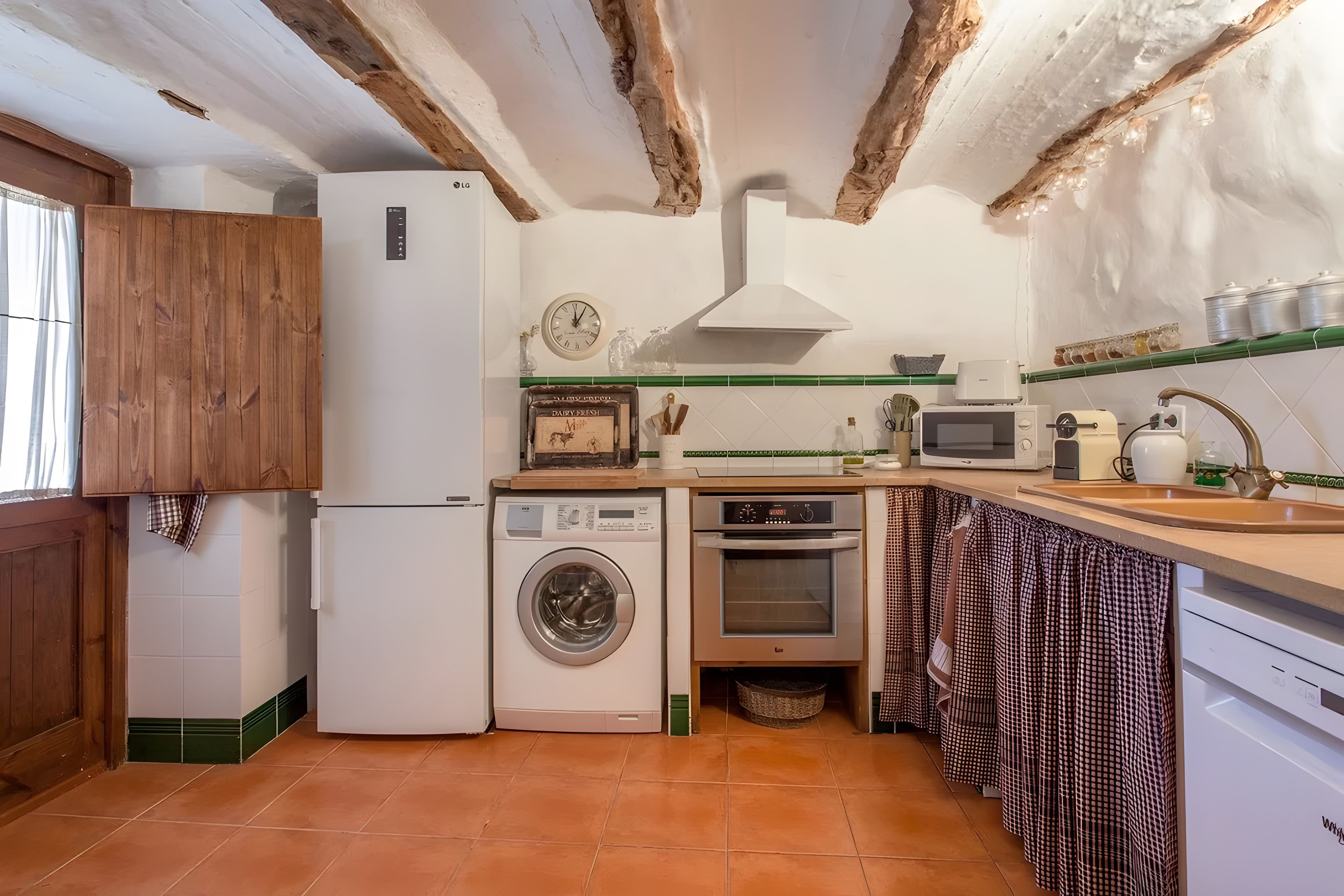 Cocina compacta con lavadora, horno y microondas.