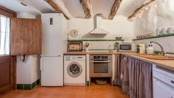 Cocina compacta con lavadora, horno y microondas.