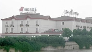 A multi-story building with balconies, a flat roof, and a signboard. - Magnolia Hotel (Wuxi)