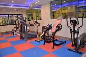Academia com diversos equipamentos de ginástica, incluindo esteiras, elíptico e bicicleta ergométrica.