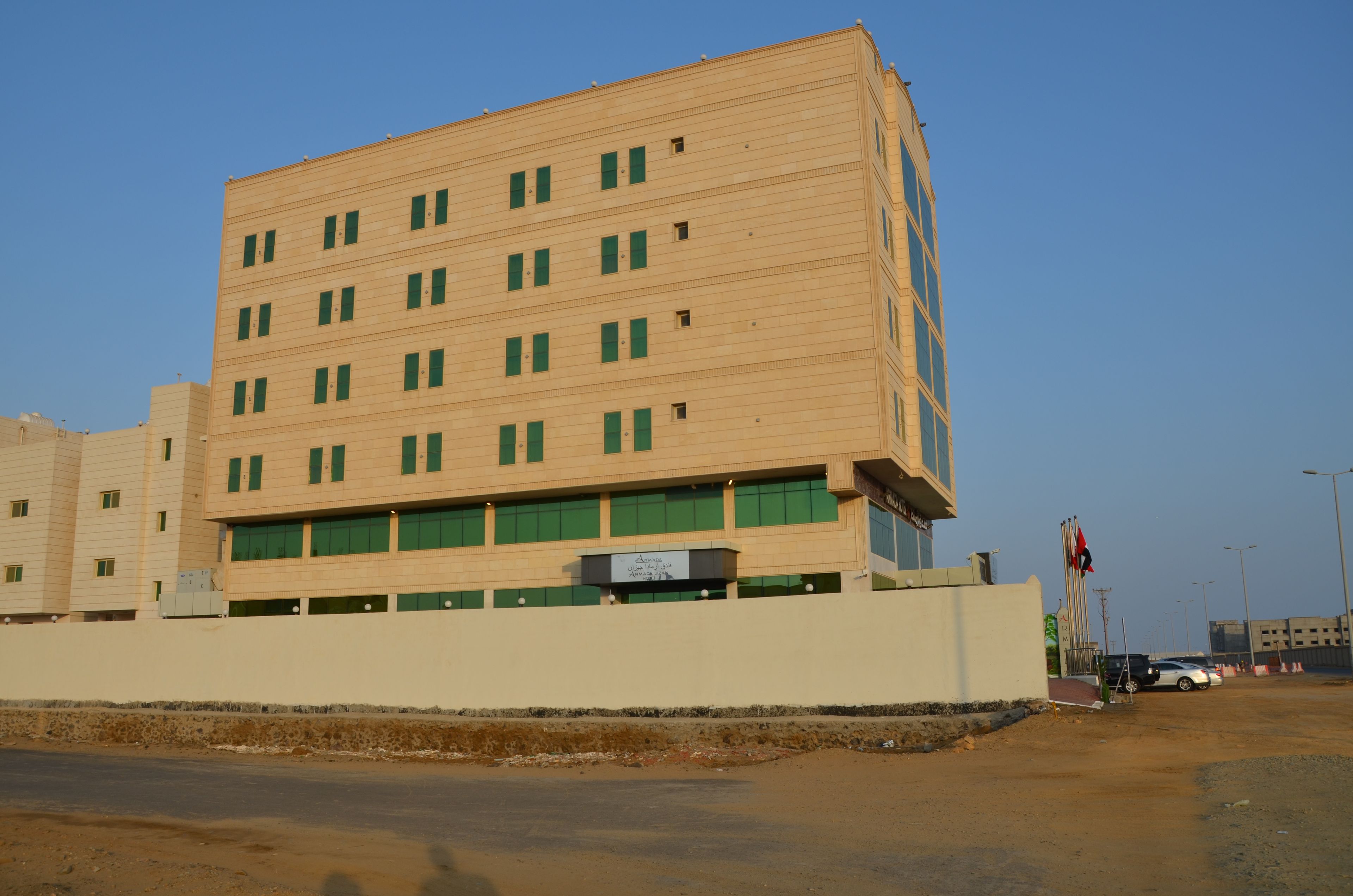 A multi-story building with a flat facade, multiple windows, and a sign indicating it is a hotel.