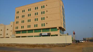 A multi-story building with a flat facade, multiple windows, and a sign indicating it is a hotel.