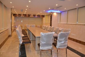 A conference room with a long table and chairs, a marble floor, and a modern ceiling with recessed lighting. - Golden New Armada (Jizan)