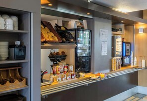 A breakfast bar with bread, condiments, and a coffee machine. - B&B Hotel Orleans Ouest La Chapelle-saint-mesmin (La Chapelle-Saint-Mesmin)
