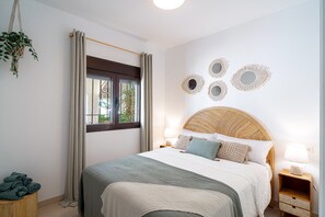 A bedroom with a bed, bedside lamps, a window with curtains, and wall decor. - Holiday Home With sea View, Nerja (Nerja)