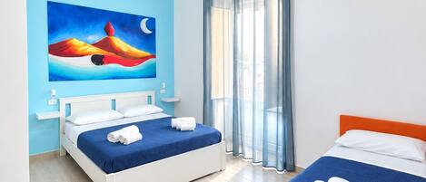 Une chambre d’hôtel avec deux lits, un tableau au mur, une fenêtre avec des rideaux et un appareil de climatisation.