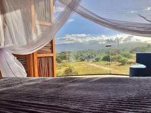 A room with a view of a rural landscape, including a dirt path and greenery. - RCH Luxury Hotel & Pool (Dibulla)