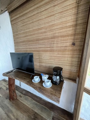 A wooden table with a laptop, a coffee maker, and cups. - RCH Luxury Hotel & Pool (Dibulla)