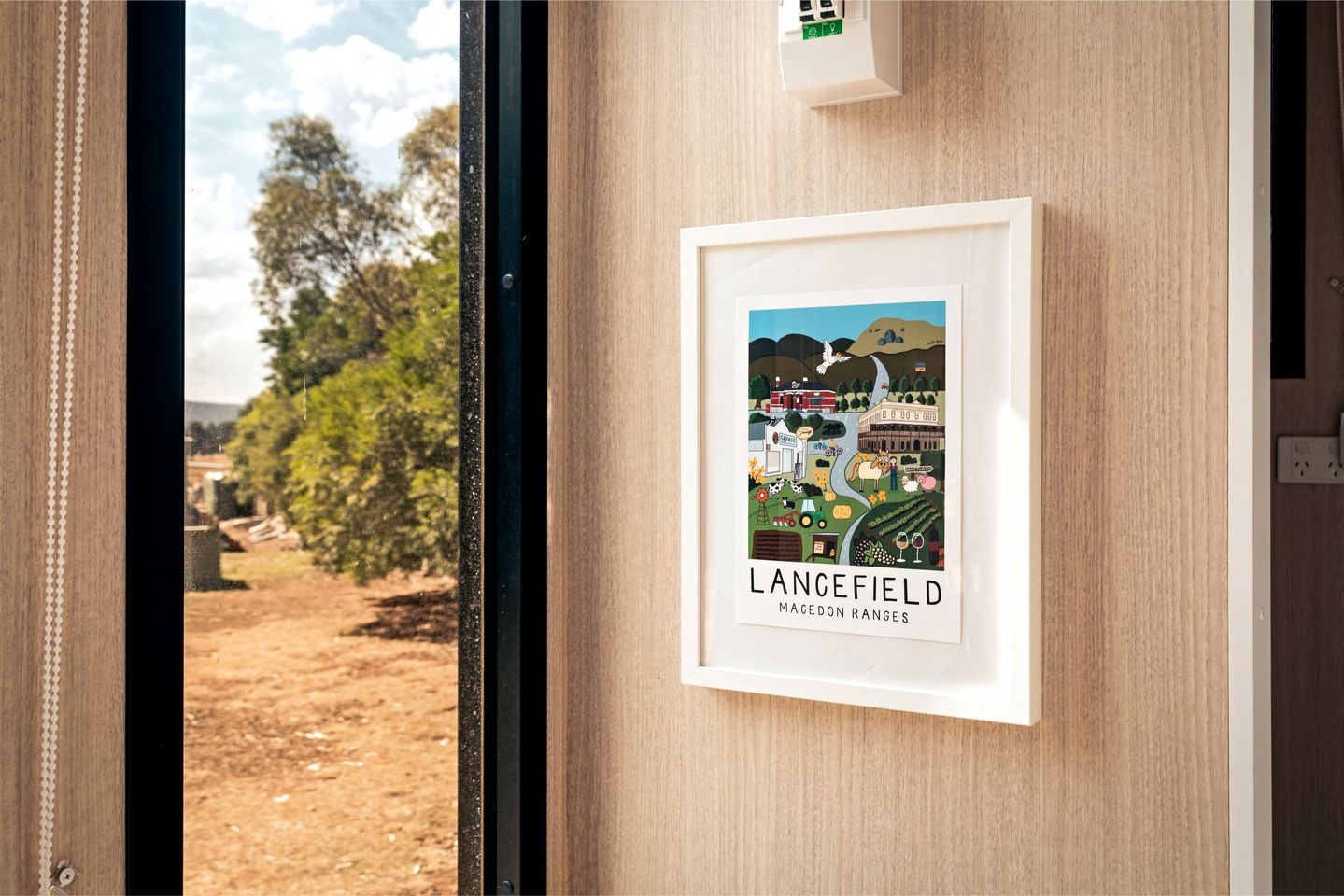 A framed picture of Lancefield in the Macedon Ranges on a wall.