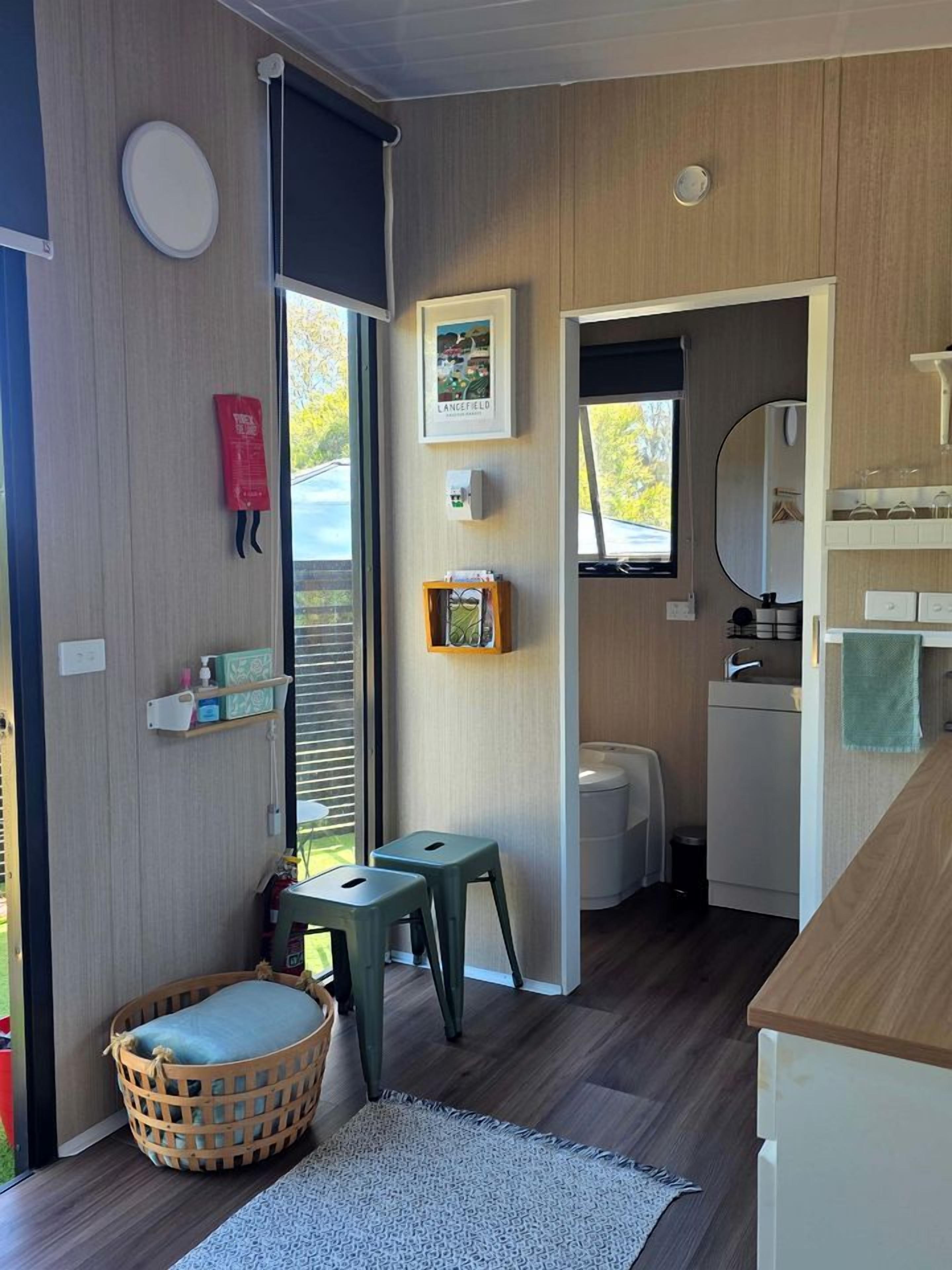 A compact living space with a kitchenette, a small dining area, and a window providing natural light.