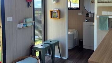 A compact living space with a kitchenette, a small dining area, and a window providing natural light.