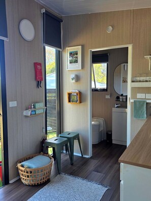 A compact living space with a kitchenette, a small dining area, and a window providing natural light.