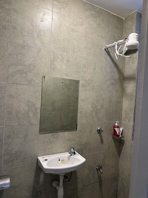 A bathroom with a sink, mirror, shower, and a towel rack. - Cynthia’s Gateway with a Swimming Pool – Stylish & Serene Stay (Nairobi)