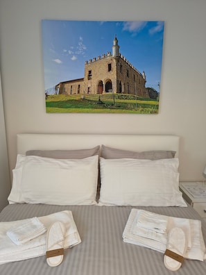 A hotel room with a bed, pillows, and towels.