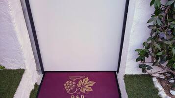 A door with a doormat that reads 'B&B FRANCIA CORTA WHITE.'