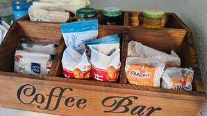 Une boîte en bois étiquetée « Bar à café » contenant divers en-cas et condiments emballés.