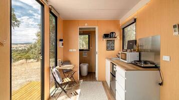 A compact kitchenette with a microwave, stove, and coffee maker.