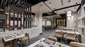 Un interior de restaurante moderno con suelo de mármol, techos altos y mobiliario contemporáneo.