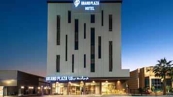 Um hotel com fachada moderna, uma placa de destaque e entrada bem iluminada.