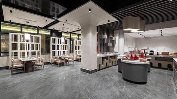 A modern interior with a central bar area, seating arrangements, and a large window providing natural light.