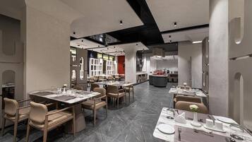 Un interior de restaurante moderno con suelo de mármol, varias mesas de comedor y sillas.
