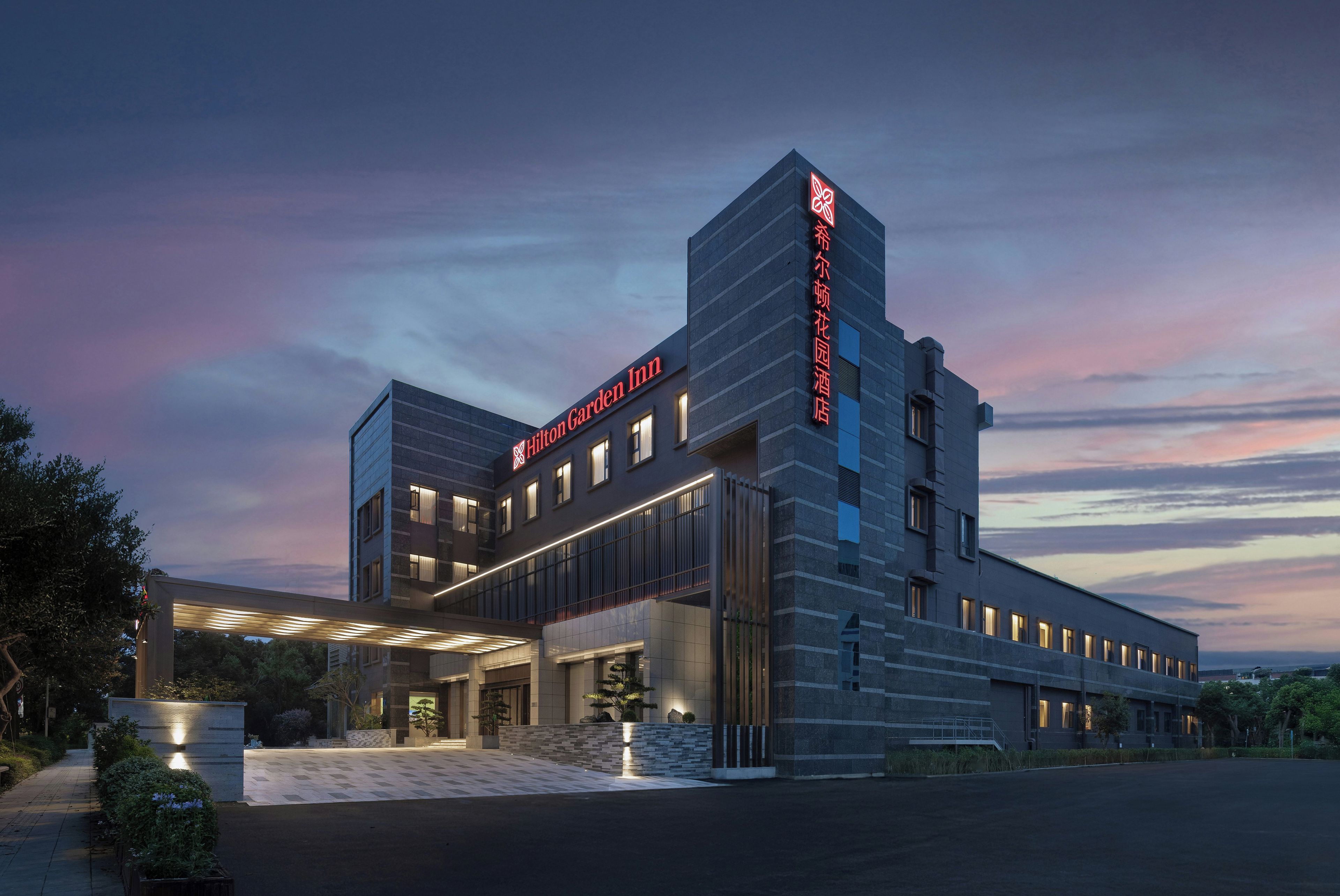 A modern hotel with a prominent entrance and a large sign.