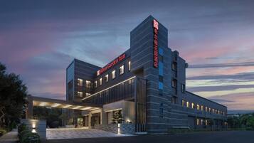 A modern hotel with a prominent entrance and a large sign.