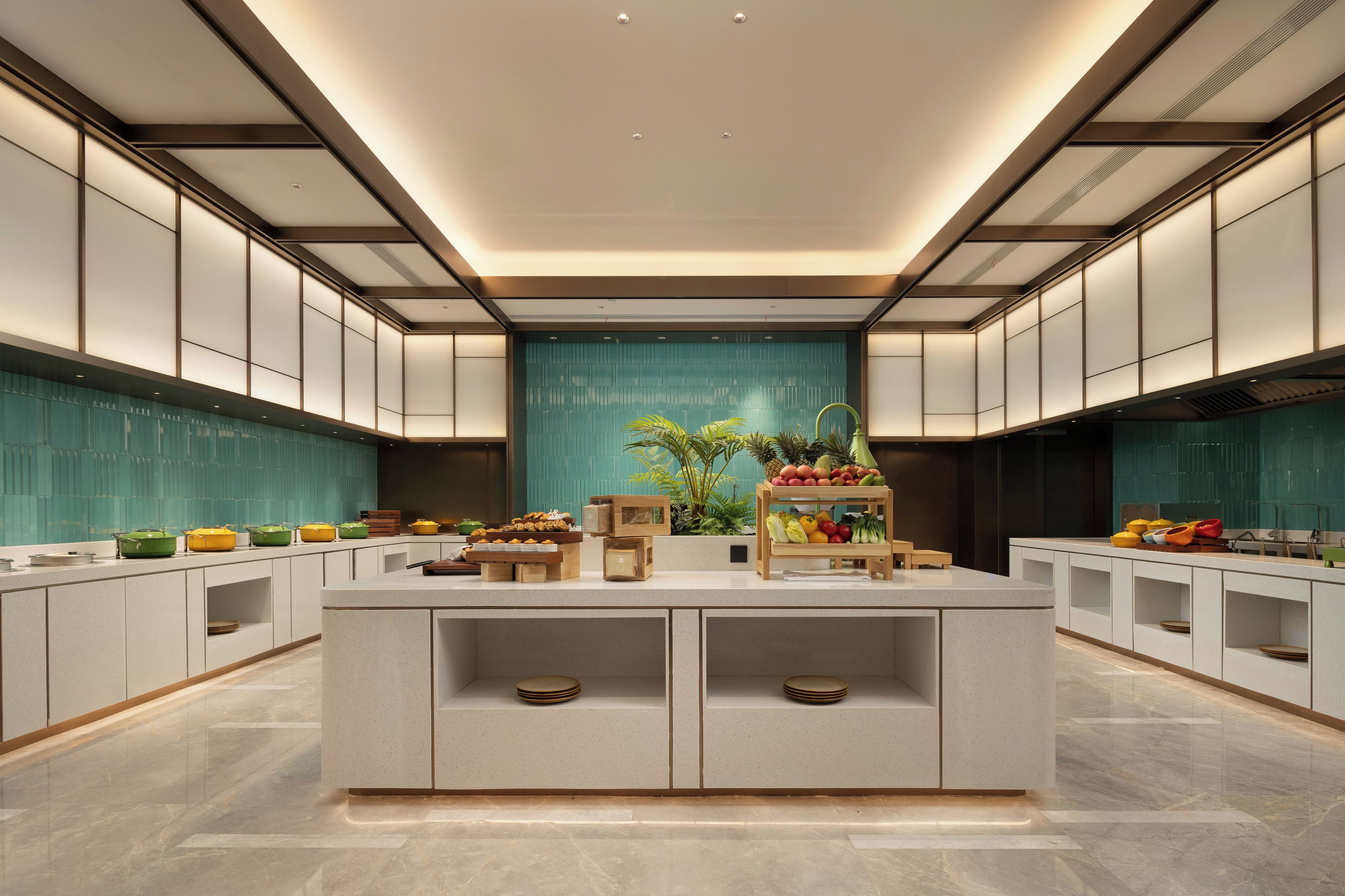 Une cuisine moderne dotée d’un îlot central, de meubles blancs et d’un pare-feu turquoise.