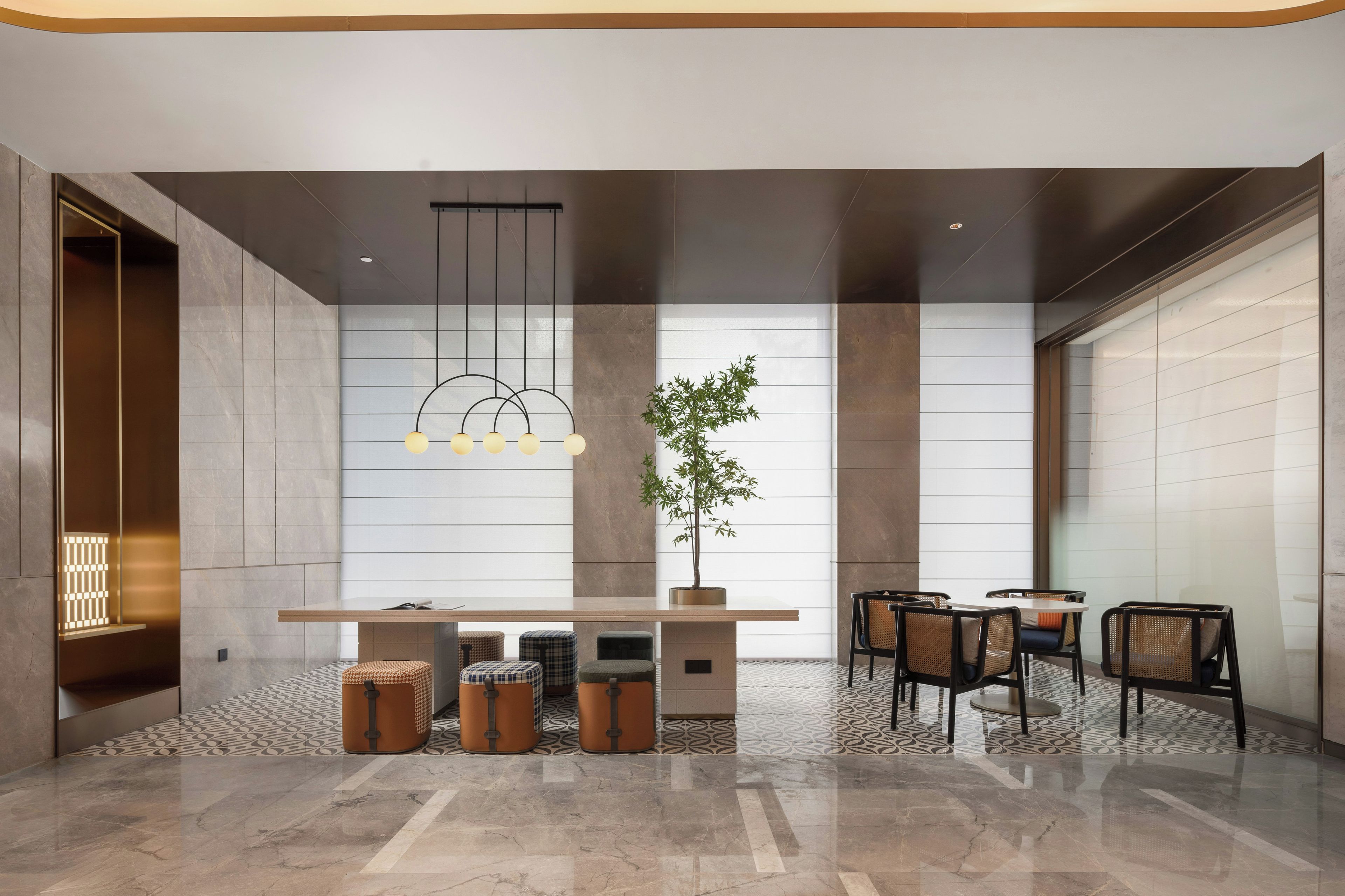 A modern interior with a central table, seating, and a hanging light fixture.