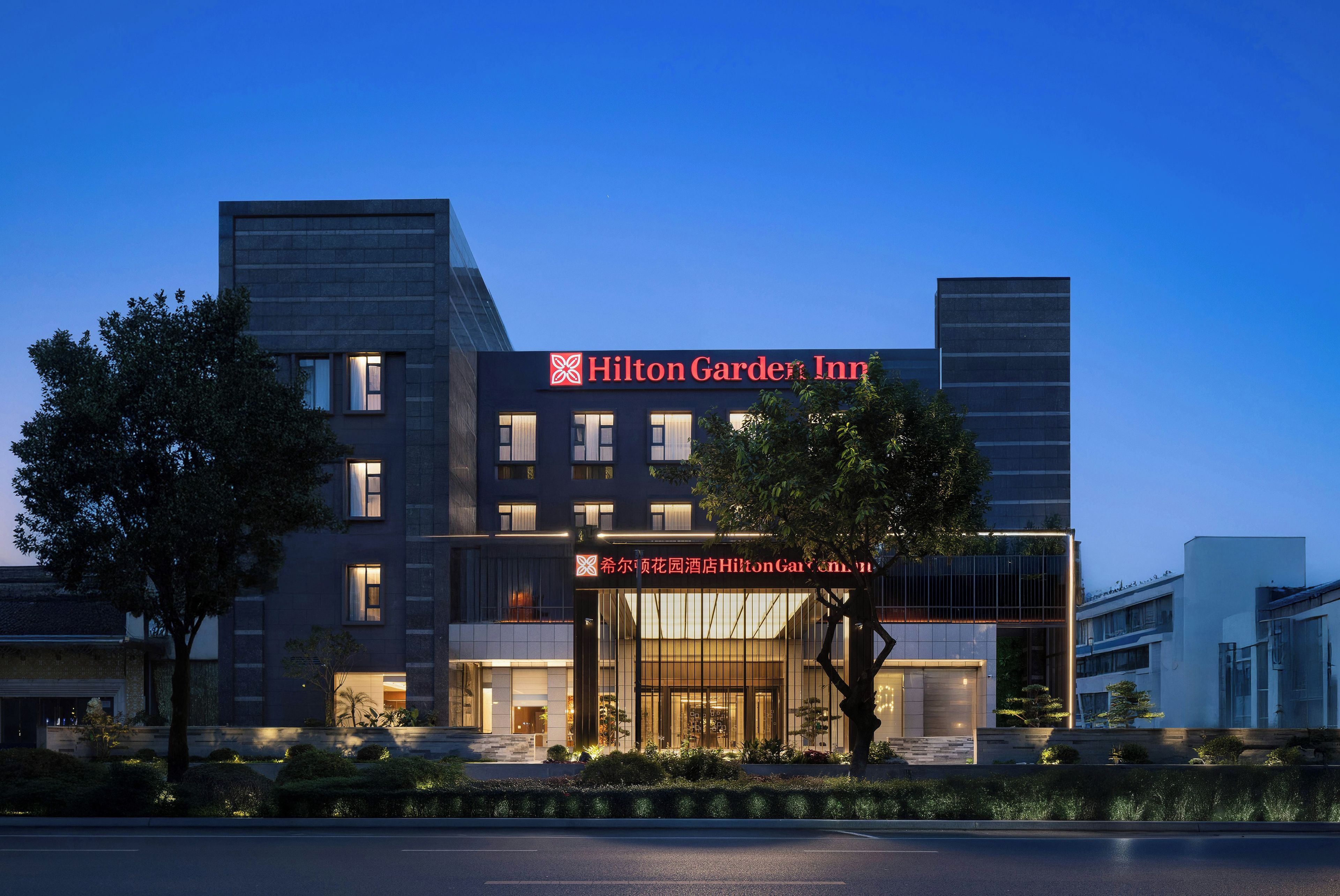Un moderno edificio alberghiero con un cartello Hilton Garden Inn ben visibile.