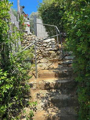 A stone staircase with metal railings leading up to a wooden fence. - Private sea-view garden near Portovenere (Portovenere)