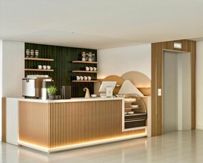 A modern reception desk with a built-in coffee machine, shelves with cups and jars, and a sleek, minimalist design. - Mekong Pano Villa (Nakhon Phanom)