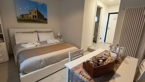 Een hotelkamer met een bed, nachtkastje en uitzicht op een gebouw.