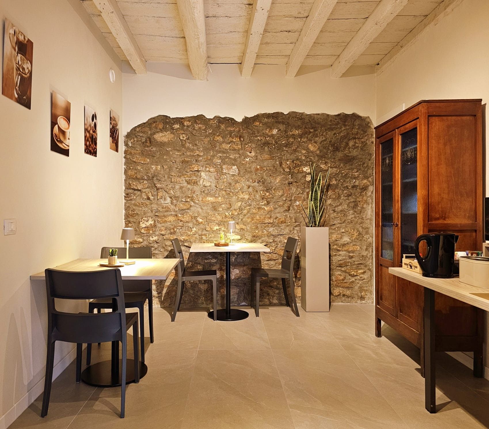 Ein gemütlicher Essbereich mit Steinwand, Holzschrank und Tisch mit Stühlen.