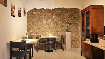 Ein gemütlicher Essbereich mit Steinwand, Holzschrank und Tisch mit Stühlen.