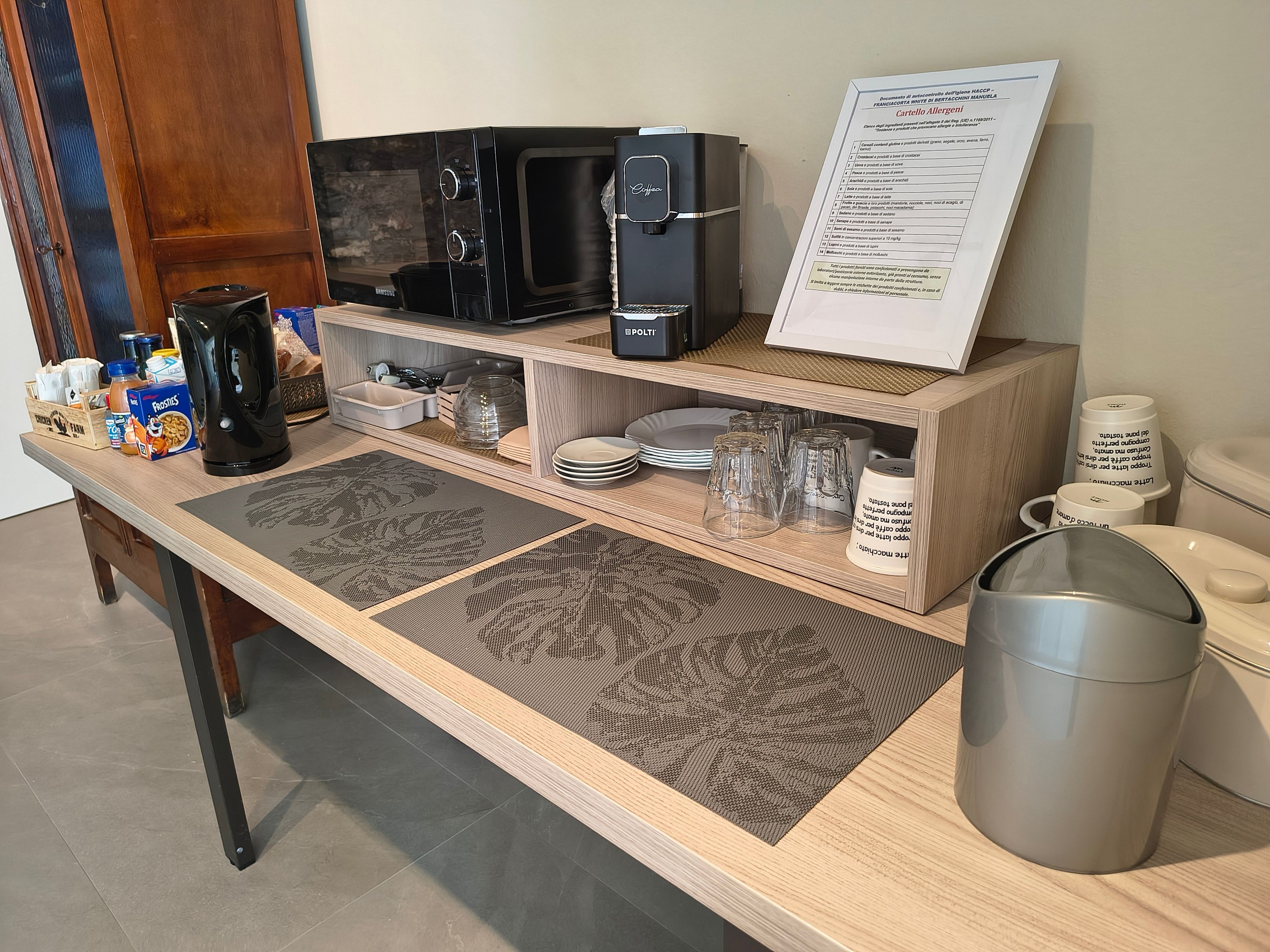 A breakfast bar with a microwave, coffee maker, and menu sign.