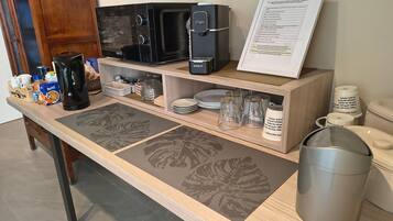 A breakfast bar with a microwave, coffee maker, and menu sign.