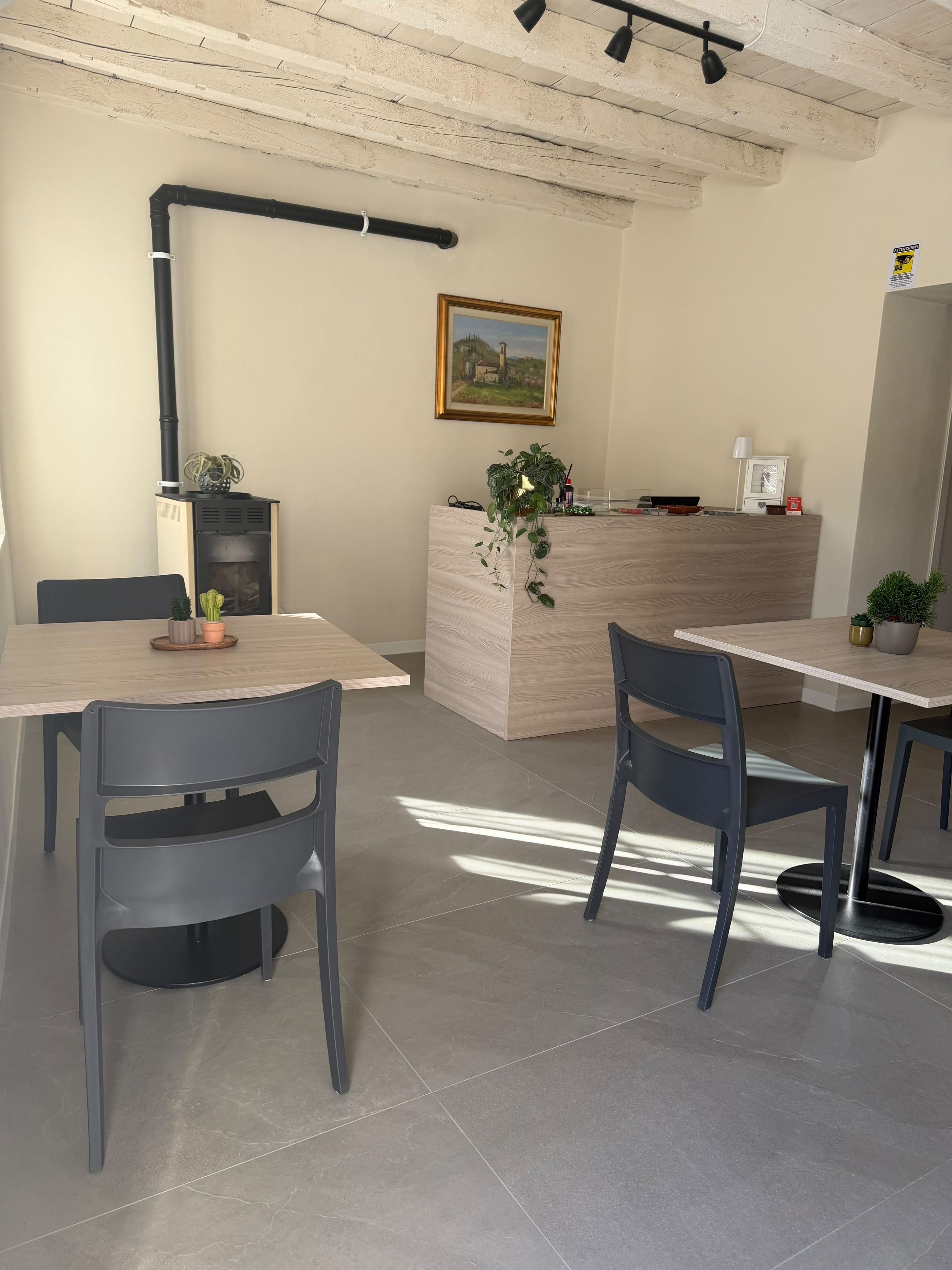 Una cocina moderna con encimera de madera, estufa negra y un cuadro en la pared.