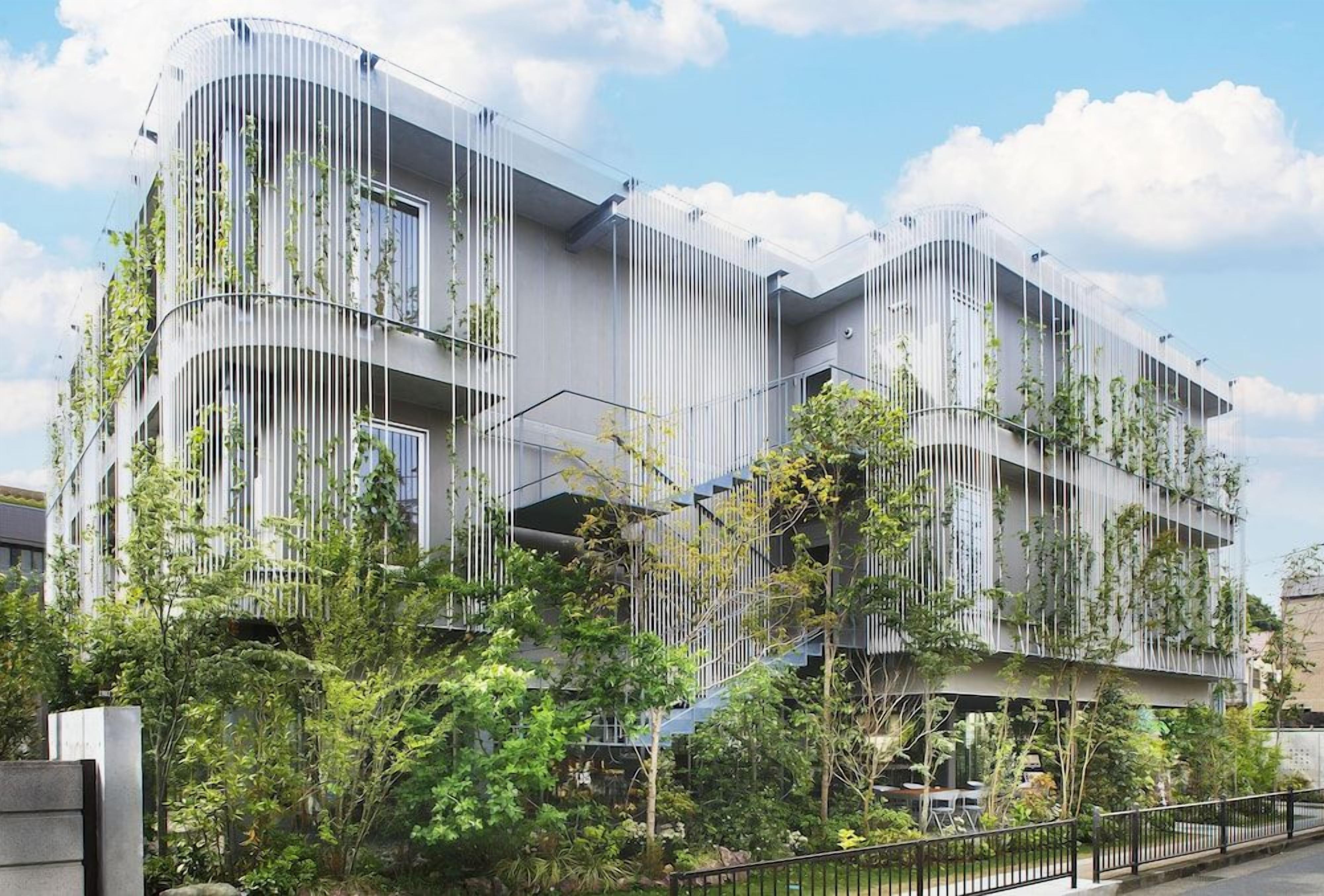 A modern building with vertical garden elements, balconies, and a curved facade.