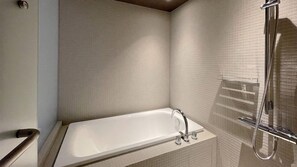 Un baño con bañera, ducha y toallero.