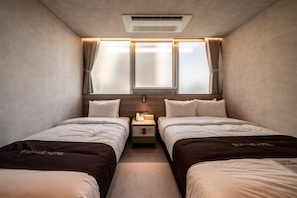 A hotel room with two beds, a bedside table with a phone, and a window with curtains. - My Me Hotel (Seoul)