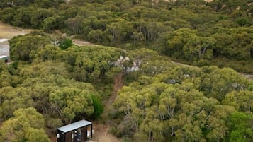 Eine abgelegene Holzhütte, umgeben von dichtem Wald, mit freiem Blick auf die umliegende Landschaft.