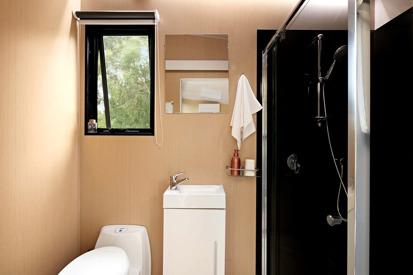 A modern bathroom with a toilet, sink, and shower.