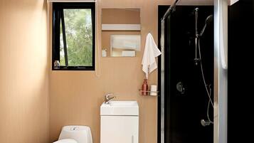 A modern bathroom with a toilet, sink, and shower.