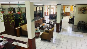 A hotel lobby with seating areas, a reception desk, and hanging plants. - Hotel Amanah Benua Cirebon (Cirebon)